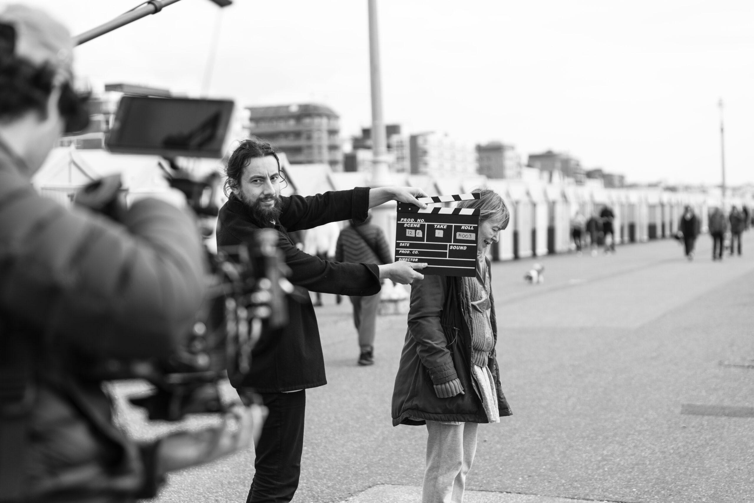 Behind the scenes on I Am Super: a clapperboard marks a take on the seafront as the camera rolls